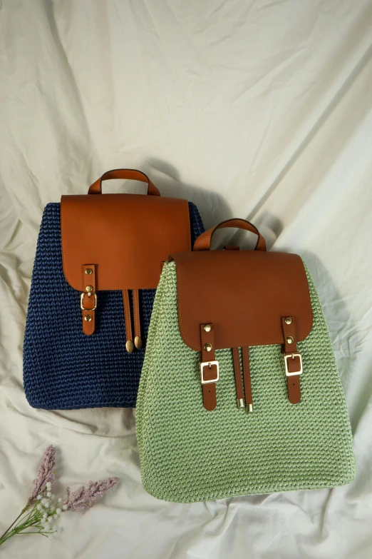 two handbags sit next to each other on a bed