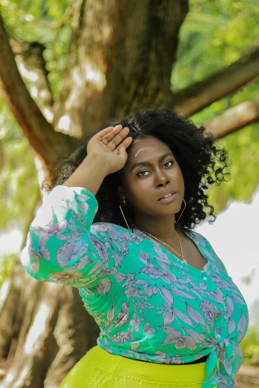 a woman wearing a green dress poses for a pograph