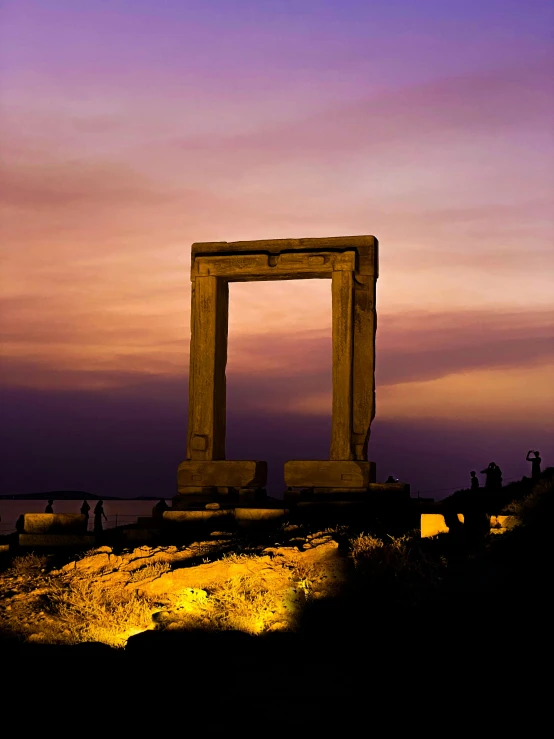 a tall monument is seen against a purple sky