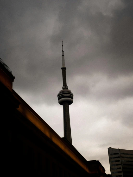 a tall tower towering over a city under cloudy skies