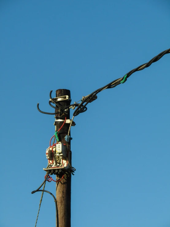 a wooden pole with an electrical wire attached to it