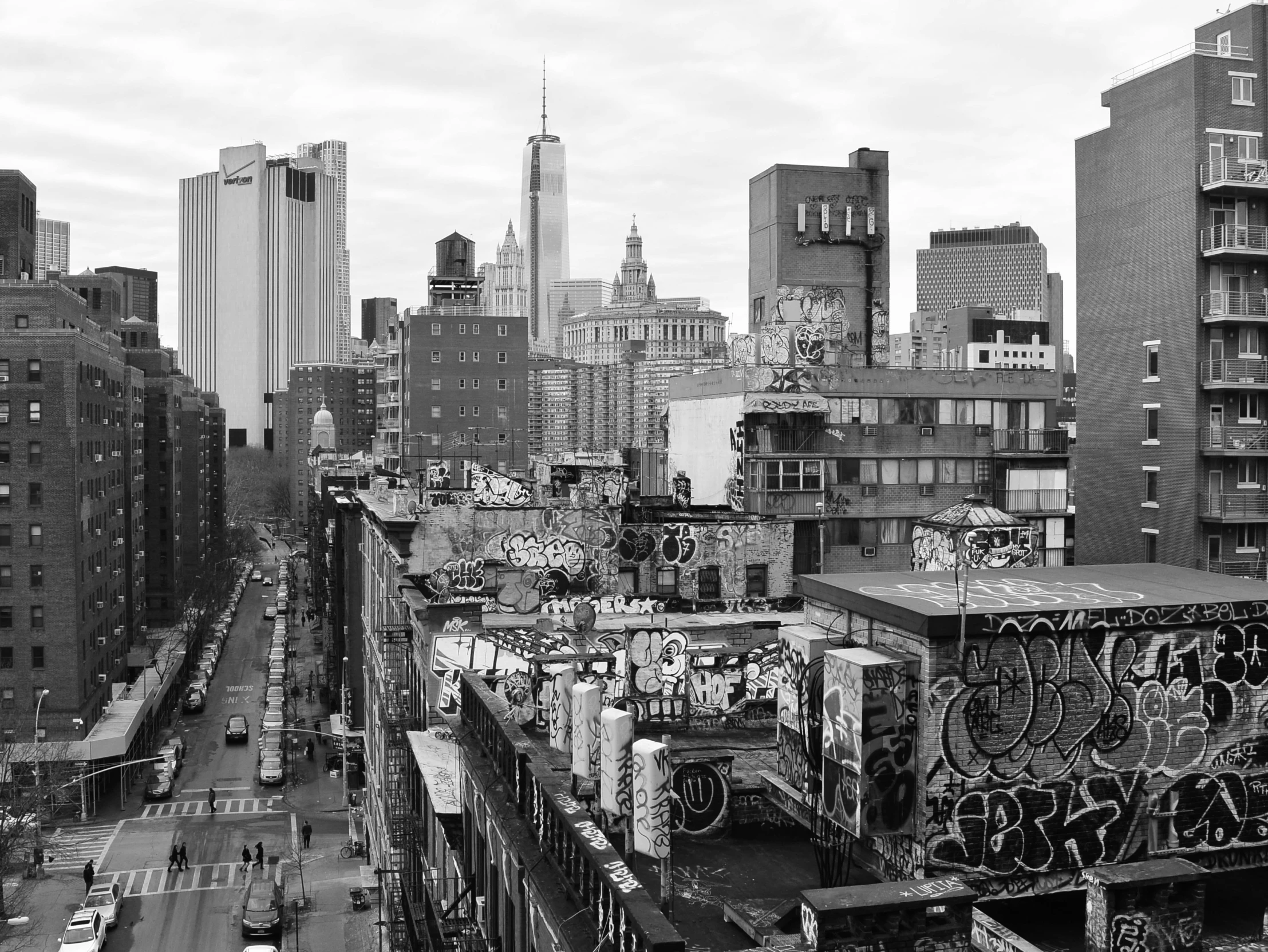 a city scene with tall buildings and graffiti on the wall