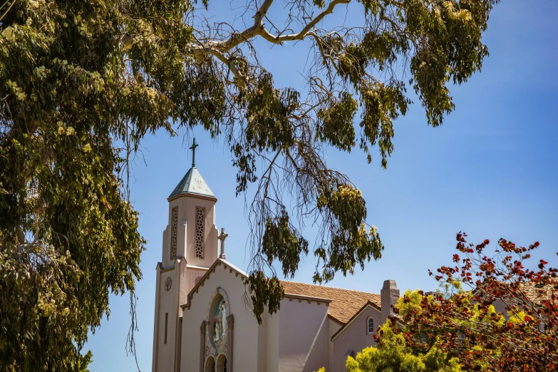 a building with a steeple on it and trees around