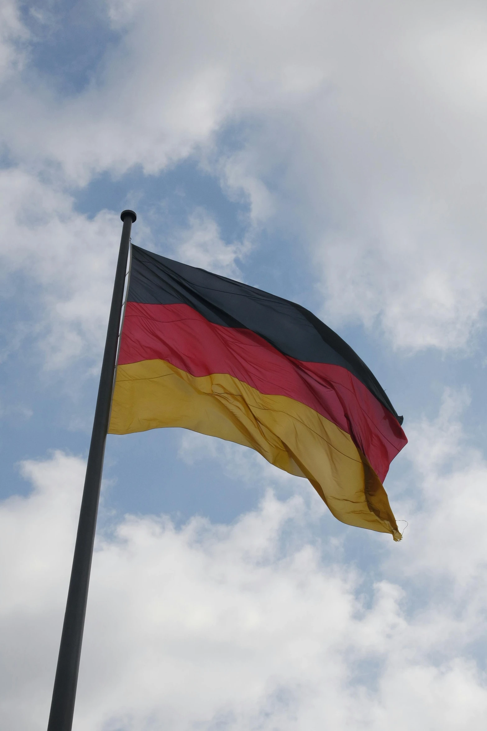 a very tall and colorful flag on top of a pole