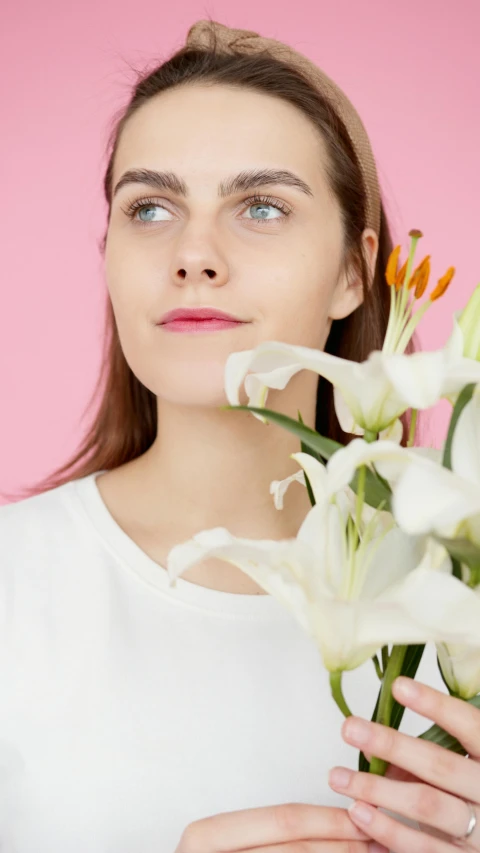 the girl is holding flowers and looking away from the camera