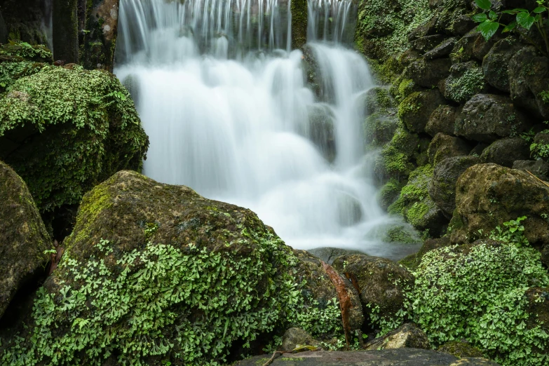 there is a large waterfall surrounded by many rocks