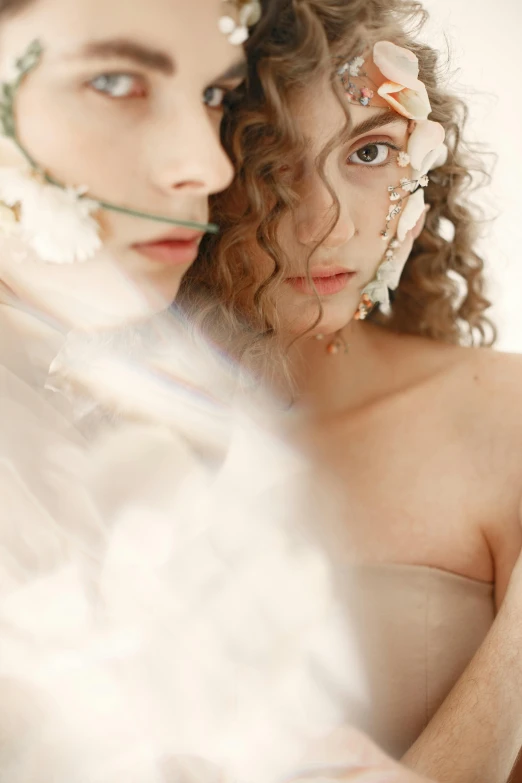 two women dressed in different poses wearing floral hair accessories