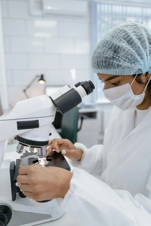 a woman looking through a microscope