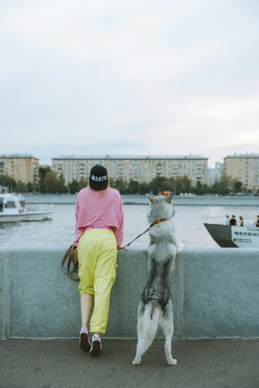 the woman is walking her dog by the water