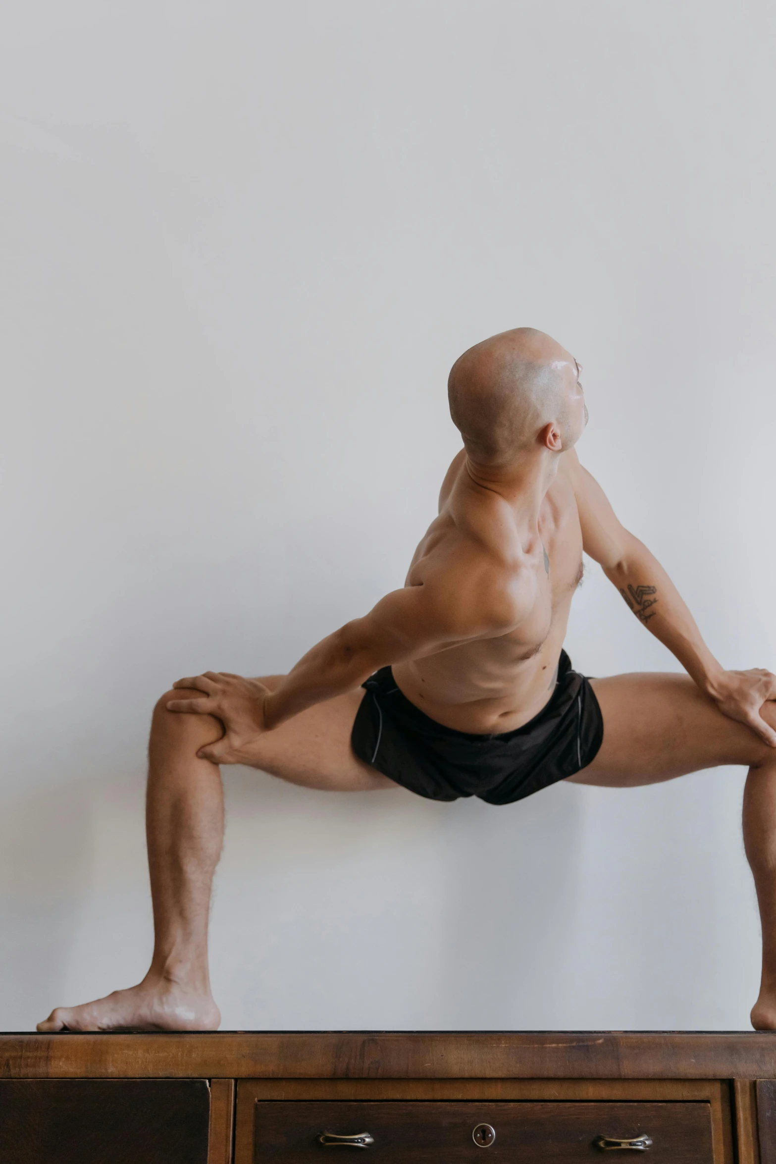 a man is doing a yoga pose on a dresser