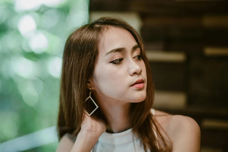 a beautiful woman wearing earrings on top of her neck