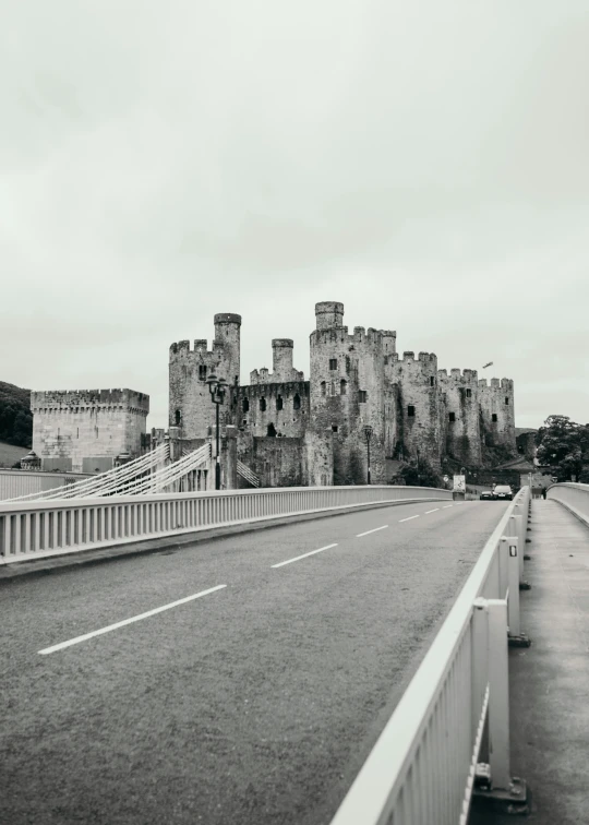 a long stretch of empty road and bridge leading to a castle