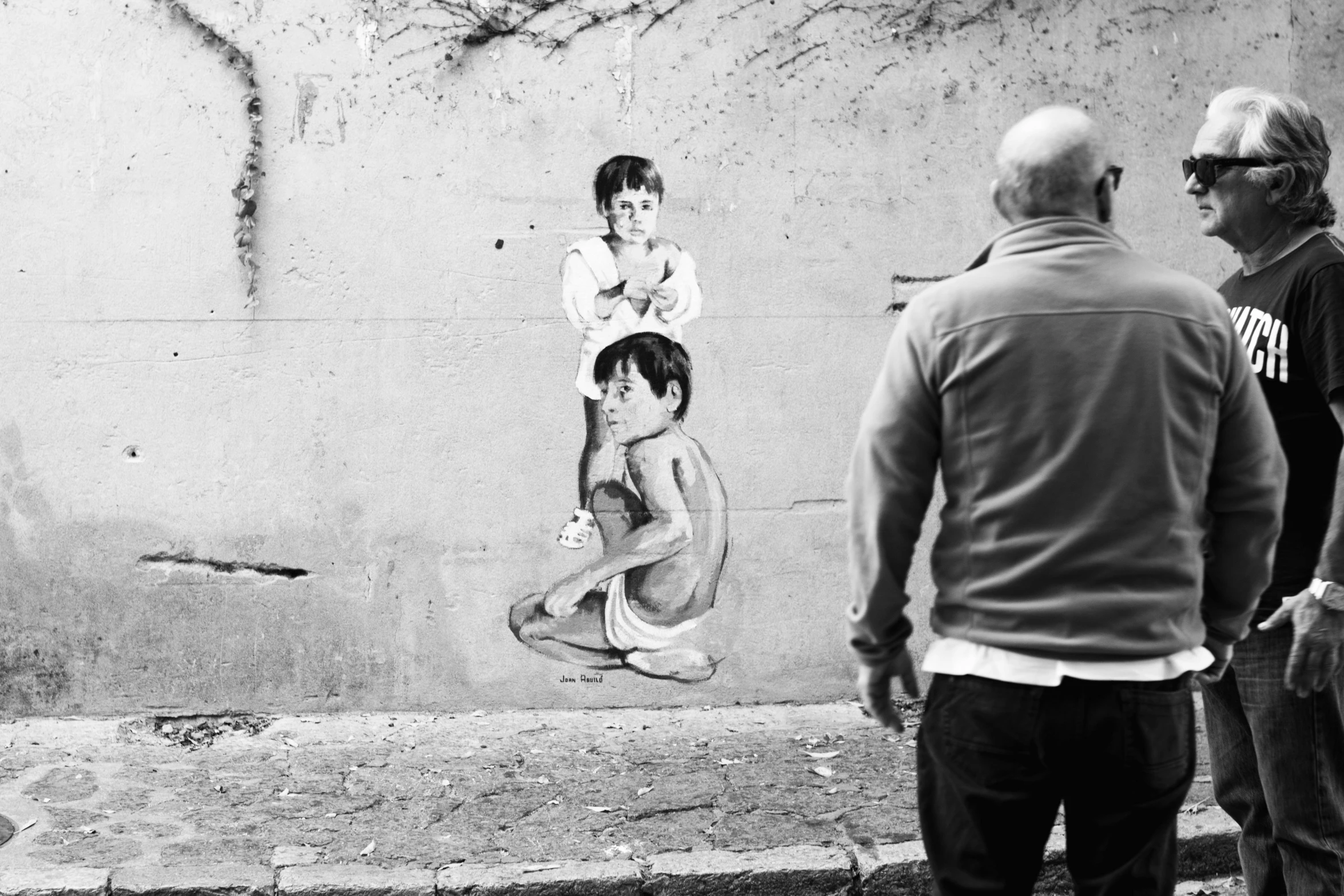 a black and white po with two men looking at the painted drawing