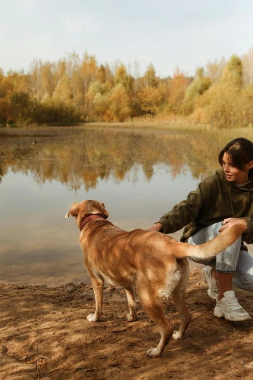 a person and a dog standing near a body of water