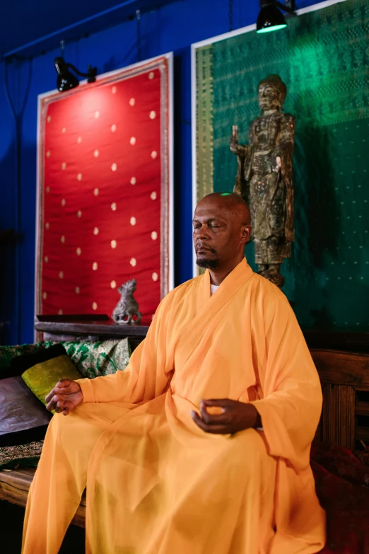 a man sitting in a room with a bright yellow cloth on it