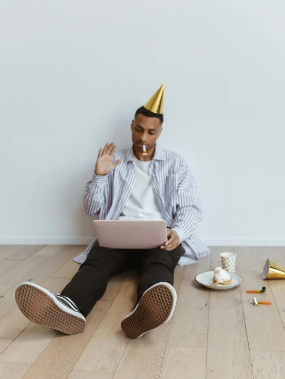 a man sitting on the floor while working with his laptop