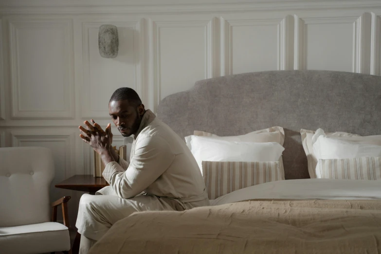 the man is sitting on the bed while clapping