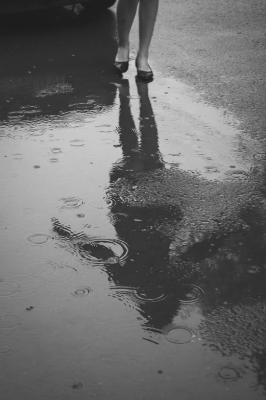 a person walking down a sidewalk in the rain