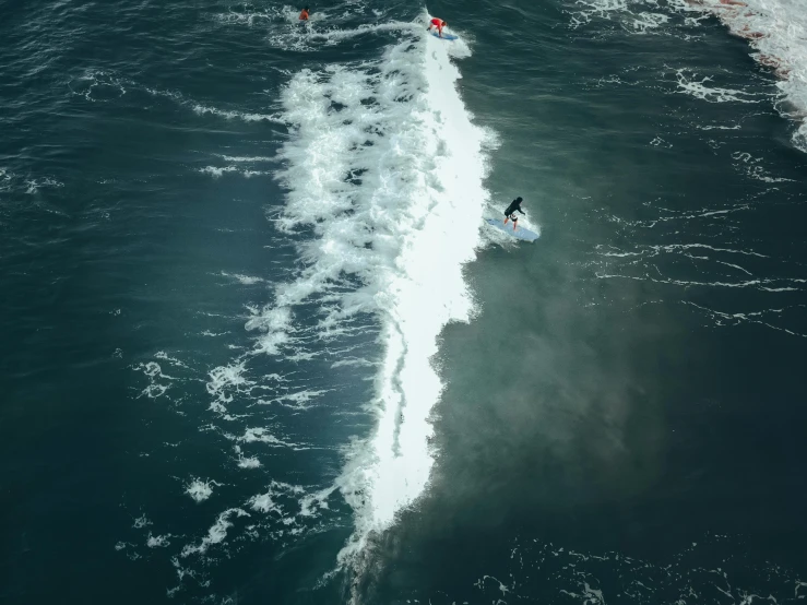 a man riding a surfboard on top of a wave