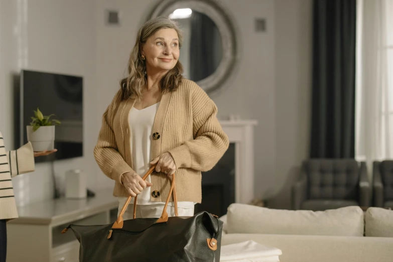 a woman standing with a large black bag