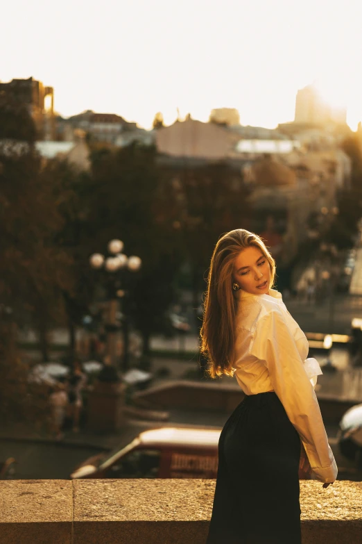 a woman looking back at the camera while standing near buildings