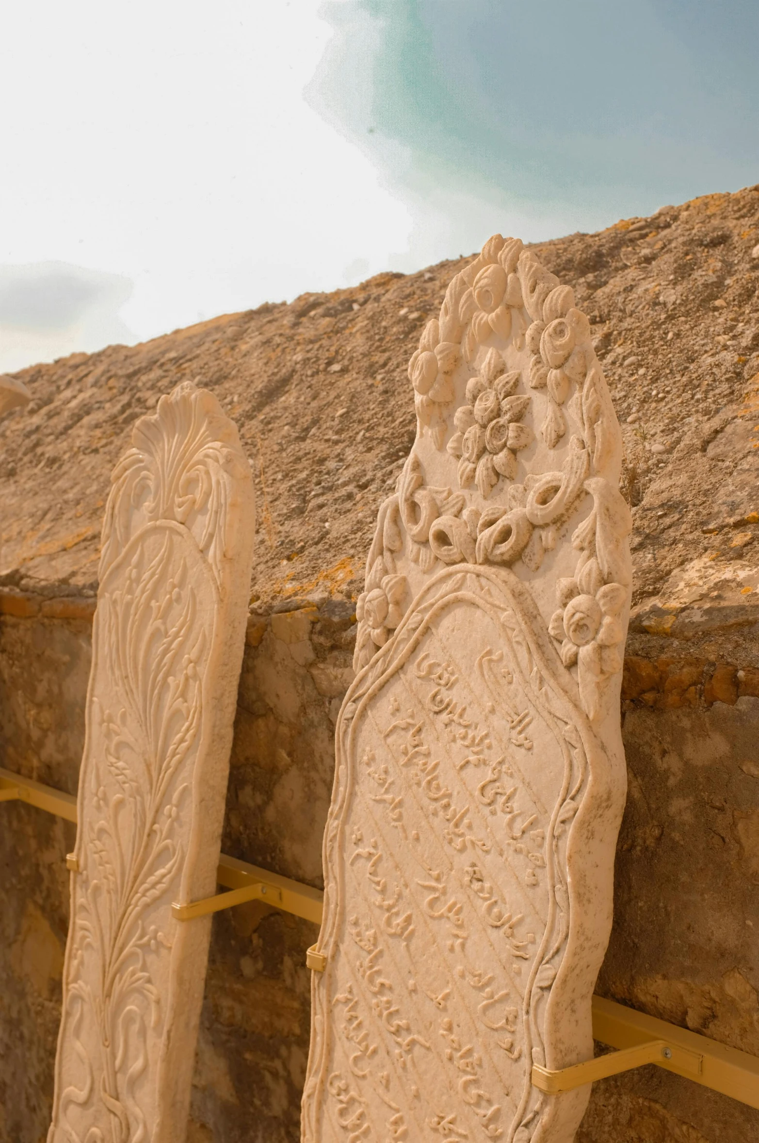 a stone carved decoration is sitting in front of a rock