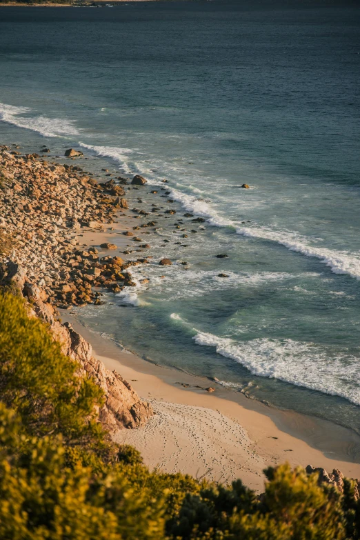 a sandy beach area on the ocean and blue waters