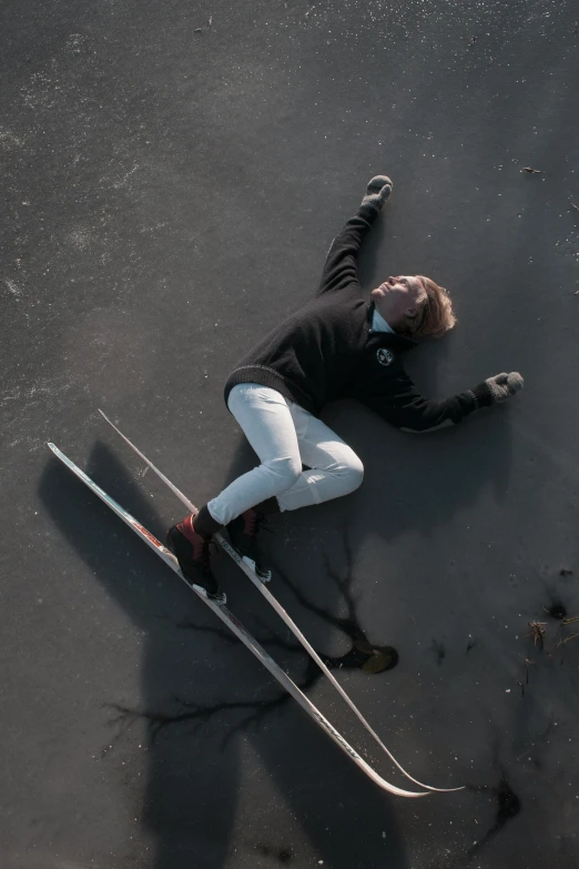 a man is laying in the middle of two skis