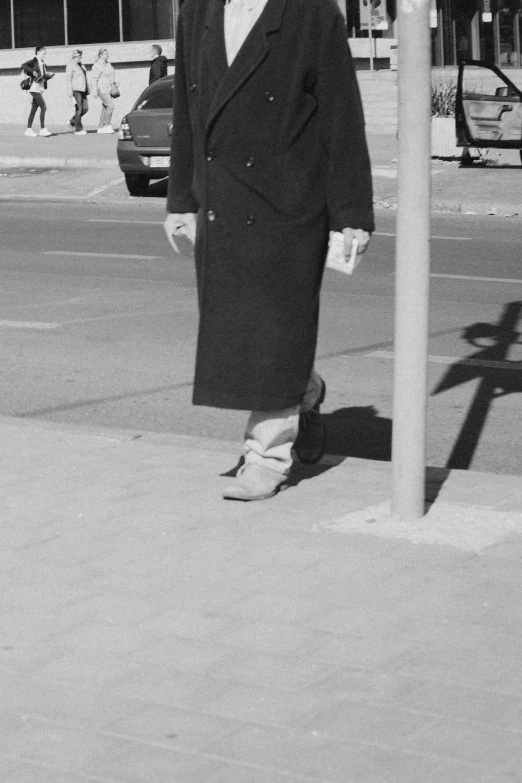 an older man is walking past a sign and another man is holding his jacket