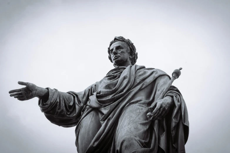 a statue with a long flowing robe on his head