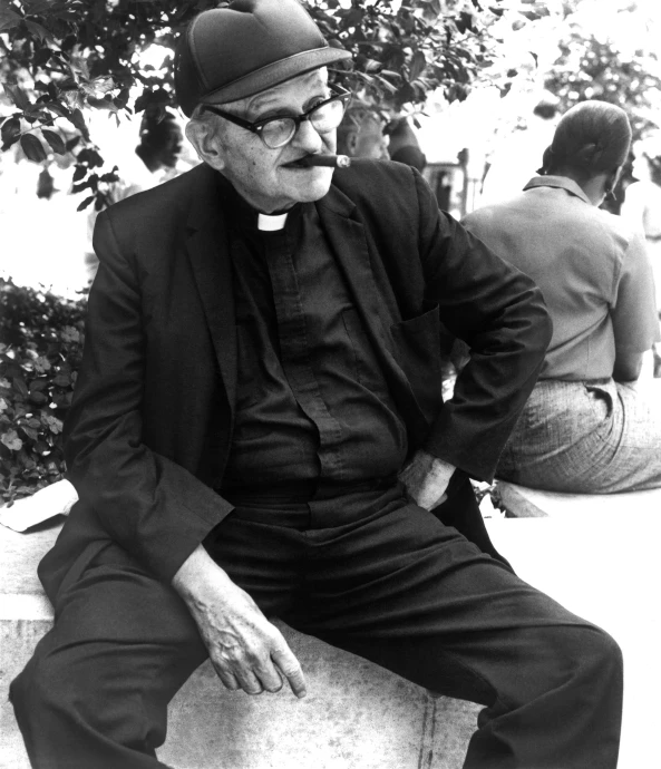 a man in glasses sitting on a stone bench