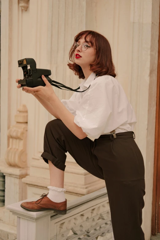 a woman posing while holding a camera