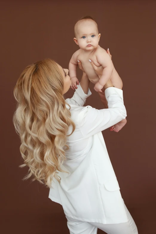 a woman holding up a baby in her hand