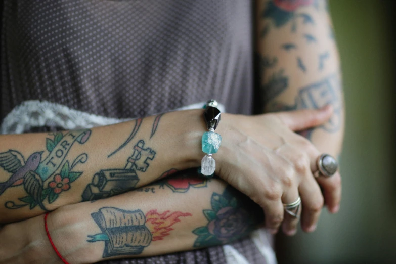 woman with tattoos holding on to her arm