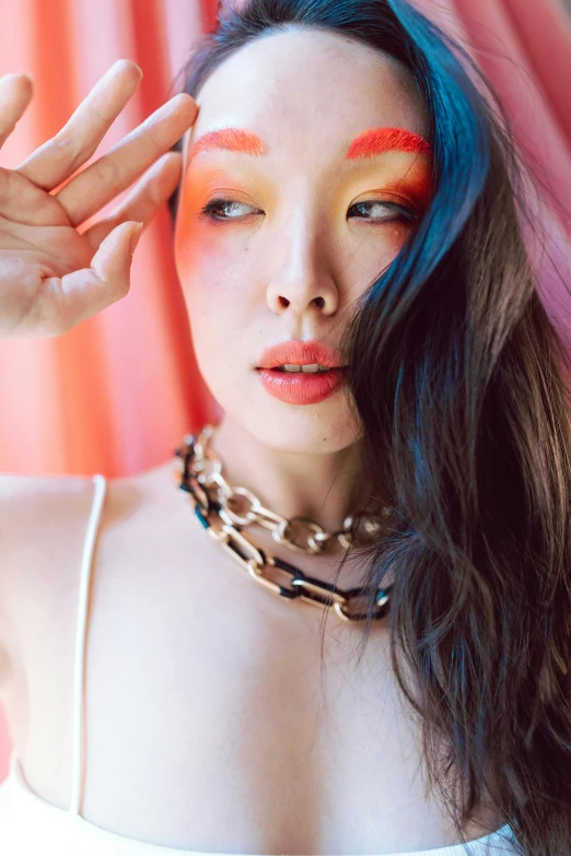 a woman with painted hands wearing a chain necklace