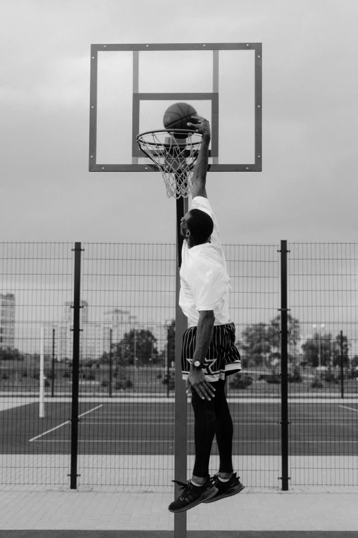 the man is about to slam the basketball in the hoop