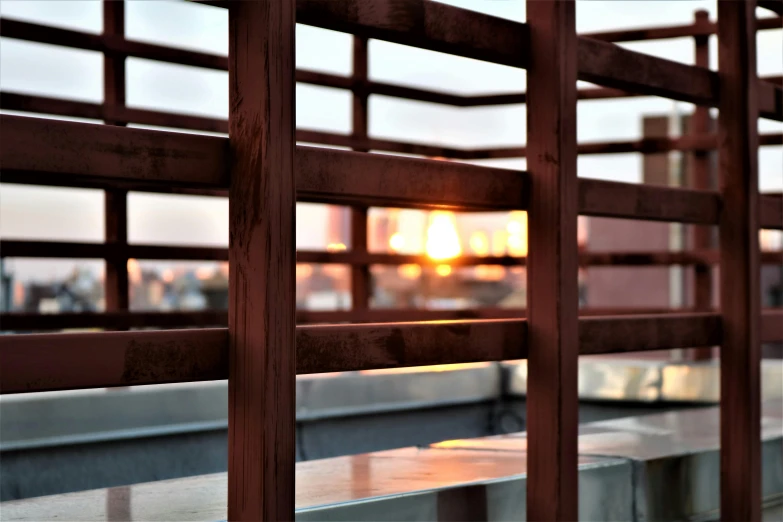 the fence is wood and has the sun reflecting in it