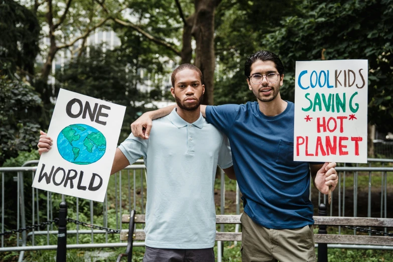 two young men holding signs in their hands