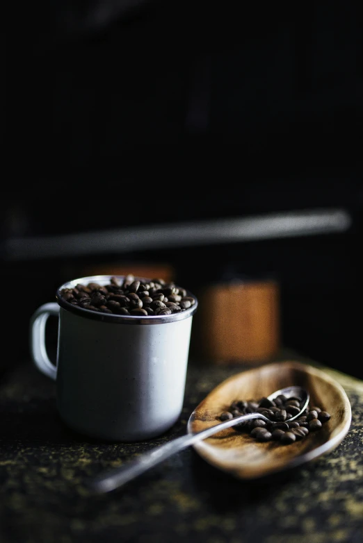 a mug filled with coffee next to a spoon