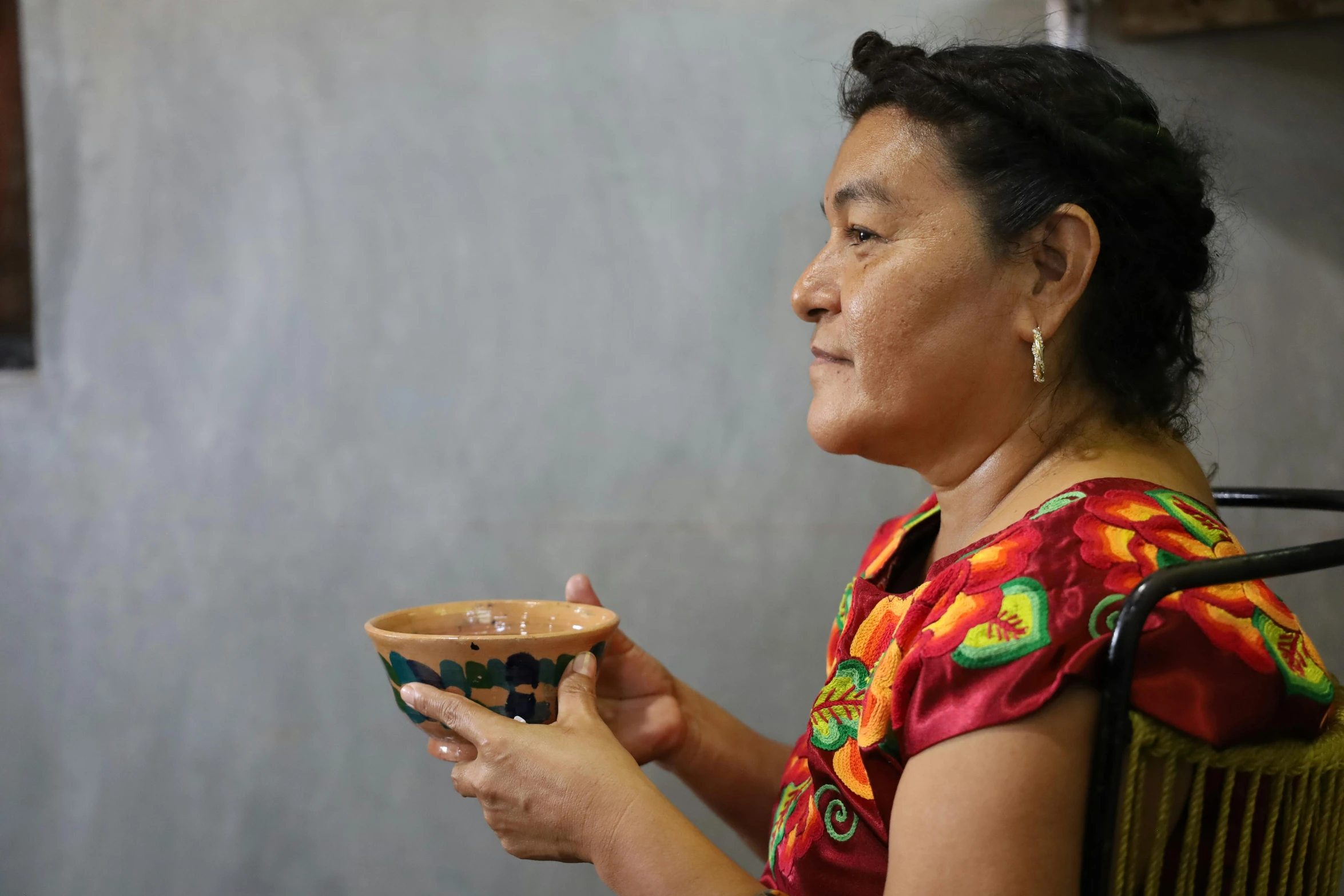 a woman holds her coffee cup in the kitchen