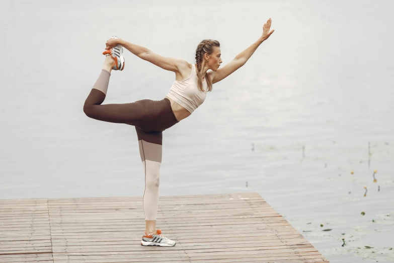 woman performing a yoga position in front of the water