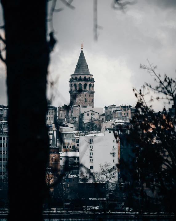 an old church tower towering over a city from across a body of water