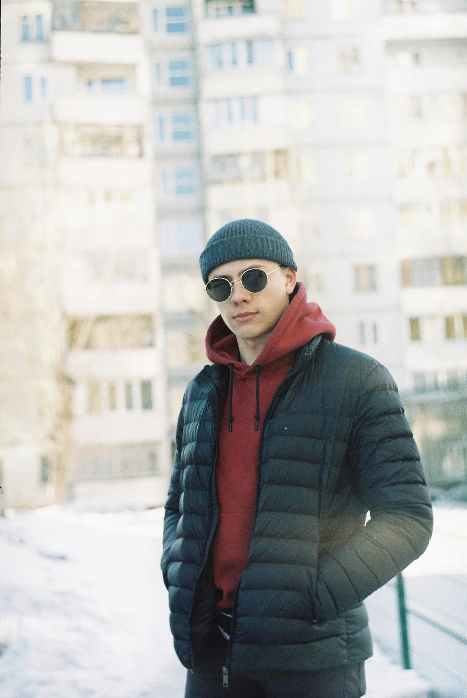 a man with a black jacket and red shirt is standing in the snow