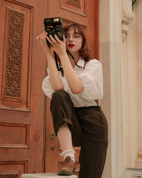 a woman sits and pographs soing with her phone