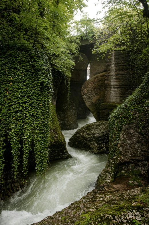 a river flowing between two stone walls that overlook them