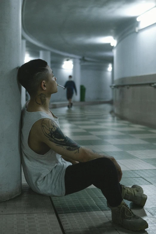 a man sitting on a wall in an otherwise empty building