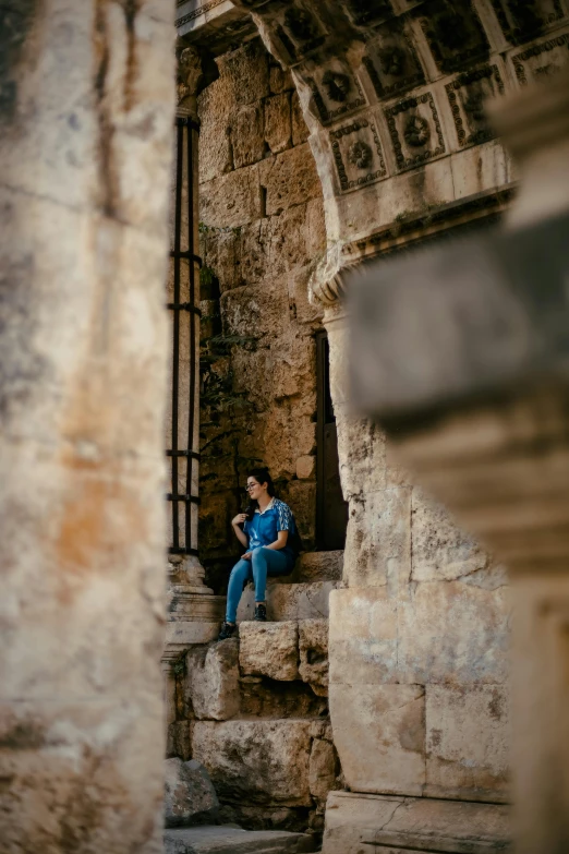 a man sitting on a stone wall near stairs