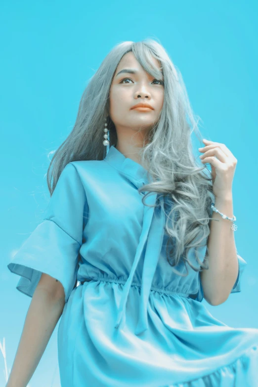 a woman with grey hair and a blue dress