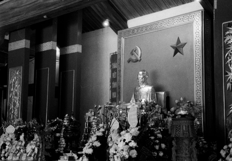 an altar with a statue and flowers next to it