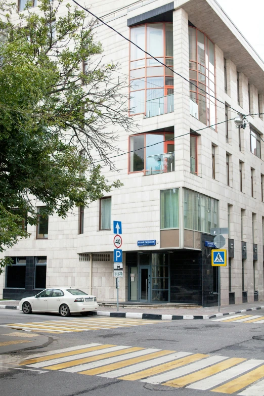 a car driving down the road near a large building